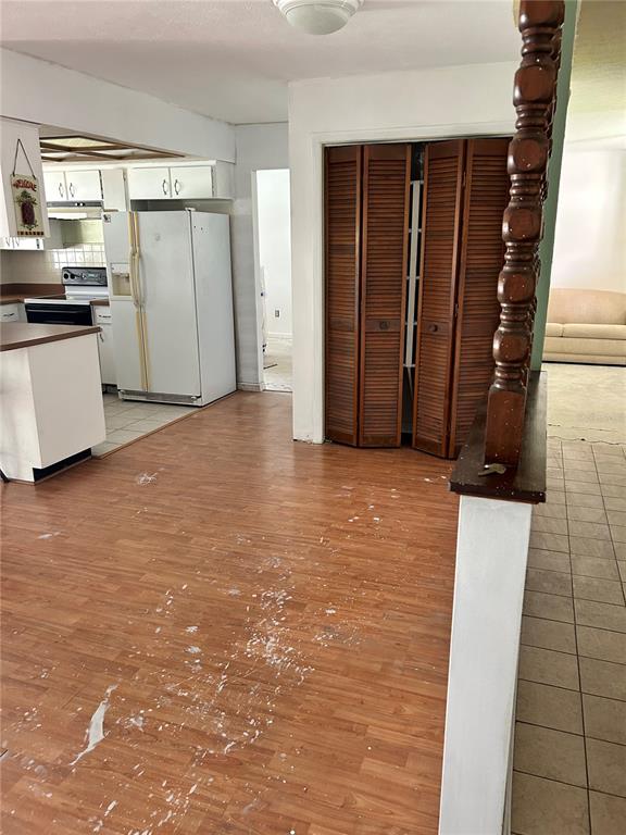 A kitchen features white cabinets, brown countertops, a tiled floor, and a recessed ceiling light — 7250 WOODBROOK DR, TAMPA, FL