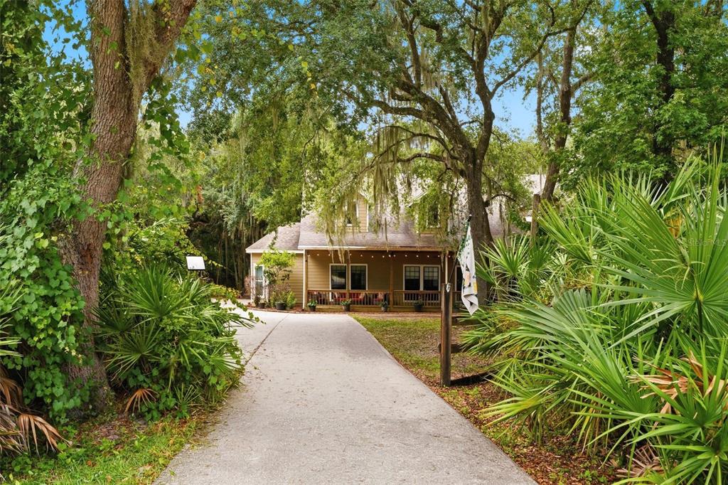 A two-story house with a wide covered front porch, dormer windows, and string lights — 381 N JUNGLE ROAD, GENEVA, FL