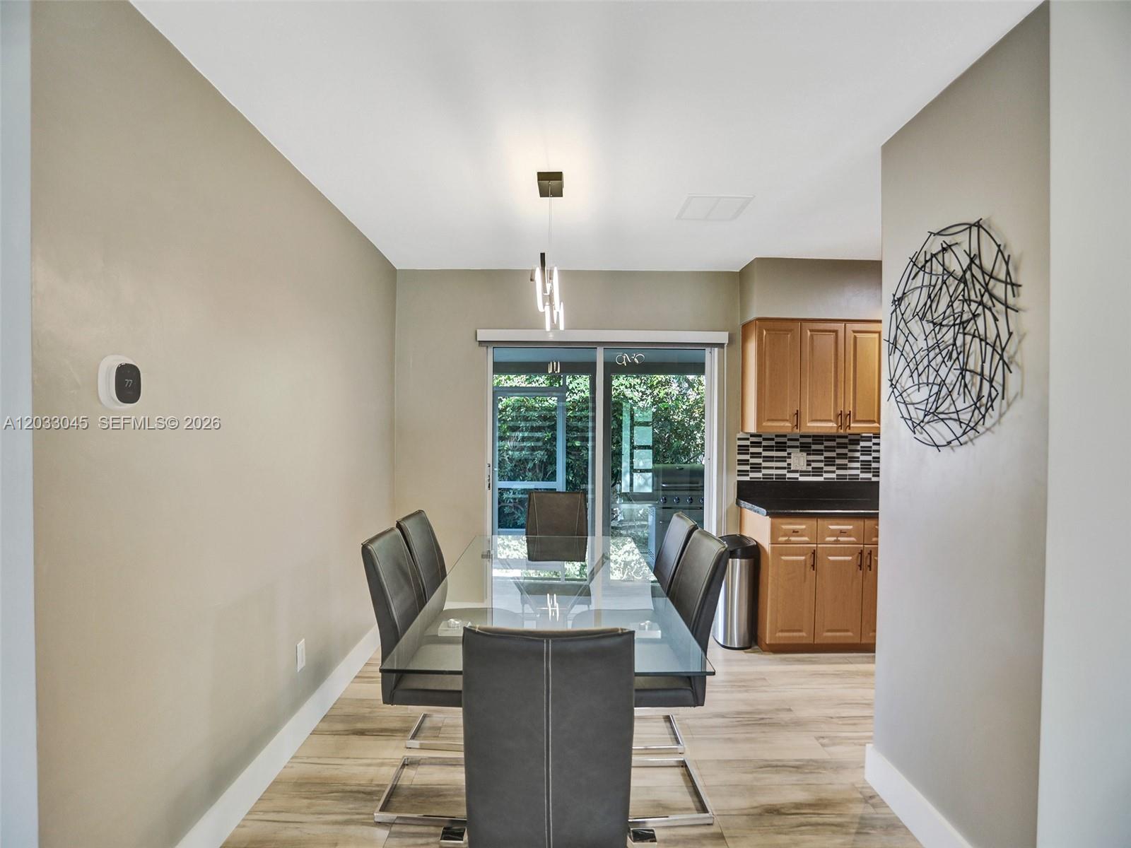 A dining room features a glass table, six chairs, and a sliding door to a patio — 491 SE 23rd Ave # 491, Pompano Beach FL 33062, POMPANO BEACH, FL
