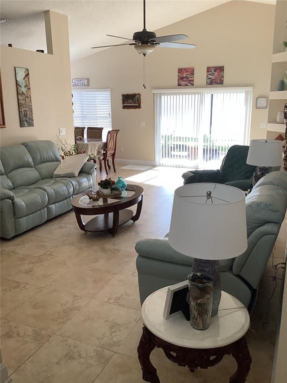 A living room features light-colored tile floors, a ceiling fan, and a sliding glass door — 514 TREE SHORE DRIVE, ORLANDO, FL