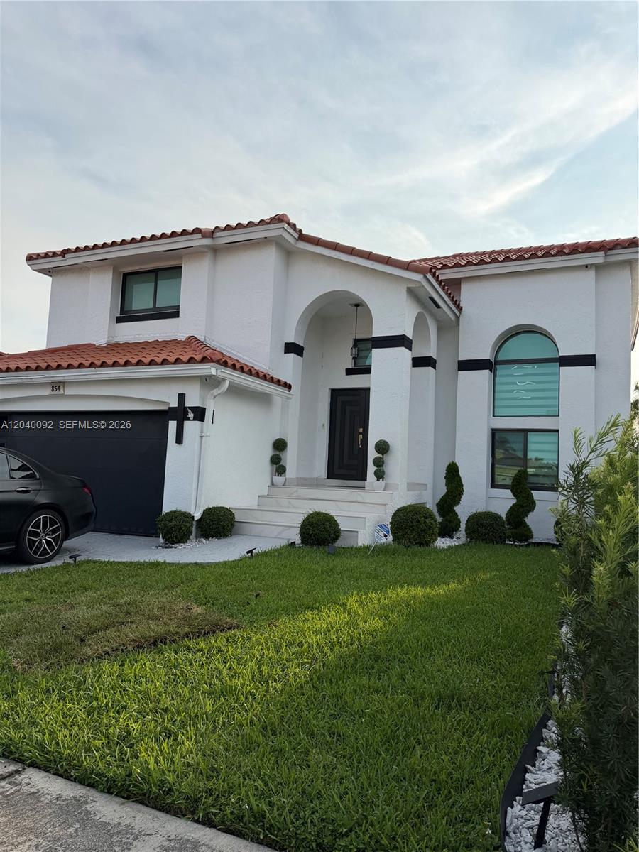 A two-story house with white stucco walls, a red tile roof, and a dark garage — 854 NW 132nd Ct, Miami FL 33182, MIAMI, FL