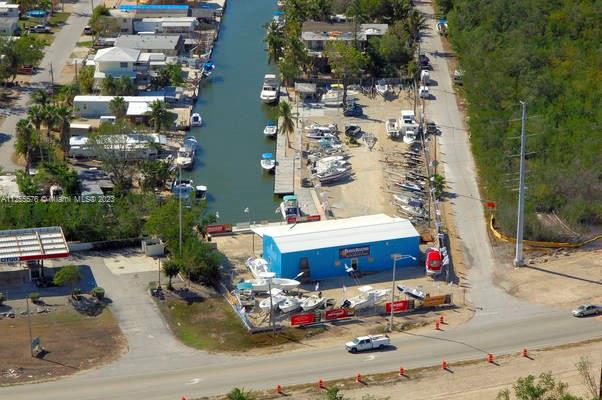 An aerial view of a blue boat storage building situated next to a canal and road — 10660 Summerland Dr, FL 33037, FL