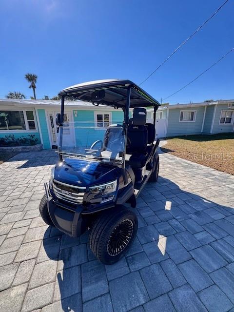 A dark blue Epic golf cart is parked on a paved driveway in front of a house — 921 E 2ND AVENUE, NEW SMYRNA BEACH, FL