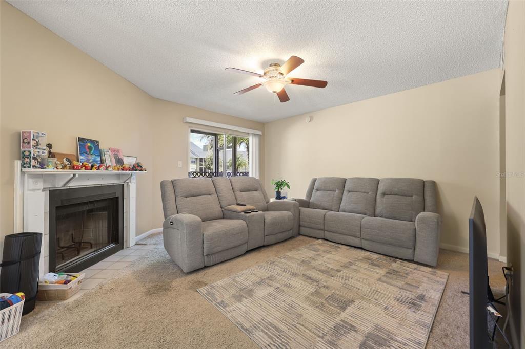 A living room features a fireplace, a gray sectional sofa, and a ceiling fan — 3729 S LAKE ORLANDO PARKWAY UNIT 5, ORLANDO, FL