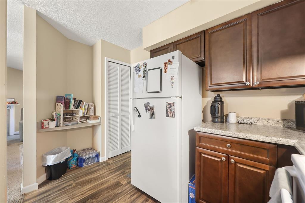 A kitchen features dark wood cabinets, granite countertops, a white refrigerator, and a small bookshelf — 3729 S LAKE ORLANDO PARKWAY UNIT 5, ORLANDO, FL