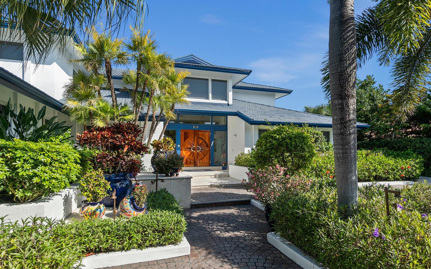 A white house with a blue roof and a wooden double door entrance — 6819 SE South Marina Way, Stuart FL 34996, STUART, FL