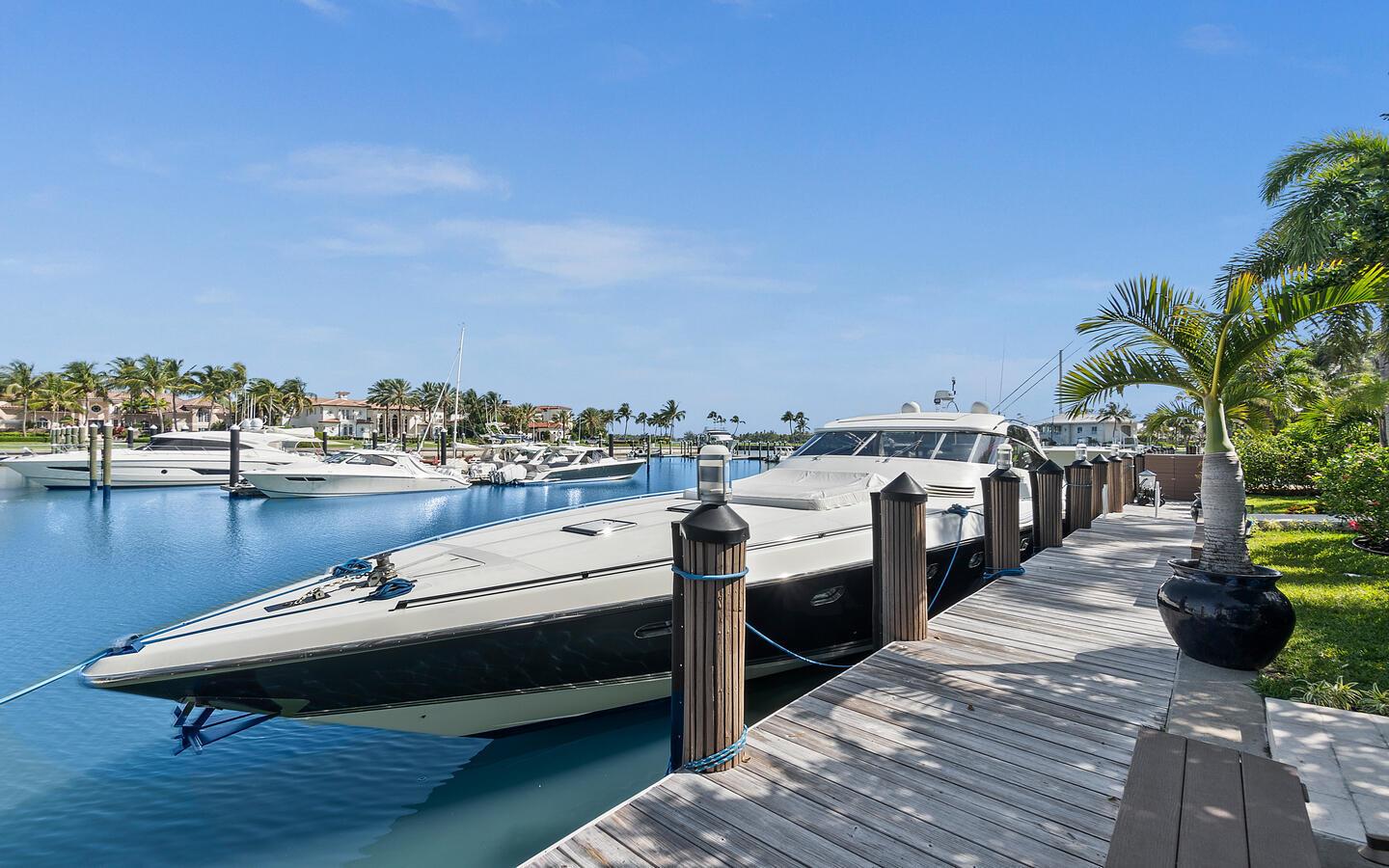 A large yacht is docked at a wooden pier alongside a tropical waterfront property — 6819 SE South Marina Way, Stuart FL 34996, STUART, FL