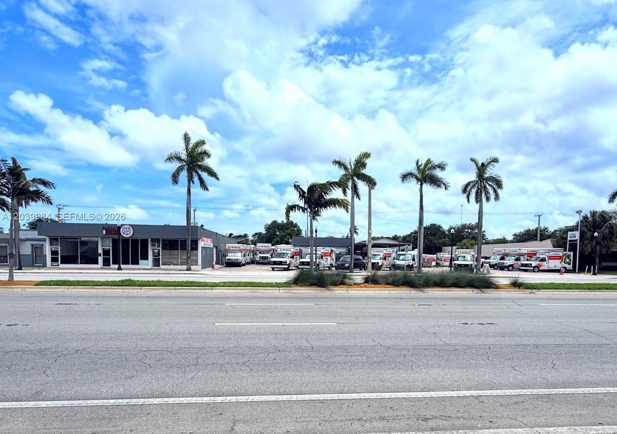 A commercial building with a row of parked U-Haul trucks and palm trees in front — 2828 Hollywood Blvd, Hollywood FL 33020, HOLLYWOOD, FL