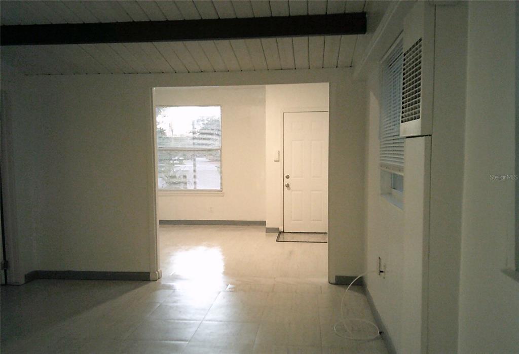 An empty room with white walls, light-colored flooring, two windows with blinds, and a door — 1060 65TH STREET S, ST PETERSBURG, FL