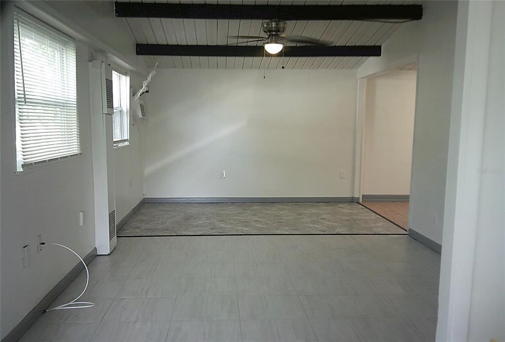 An interior view shows a tiled room with a white door and a window — 1060 65TH STREET S, ST PETERSBURG, FL