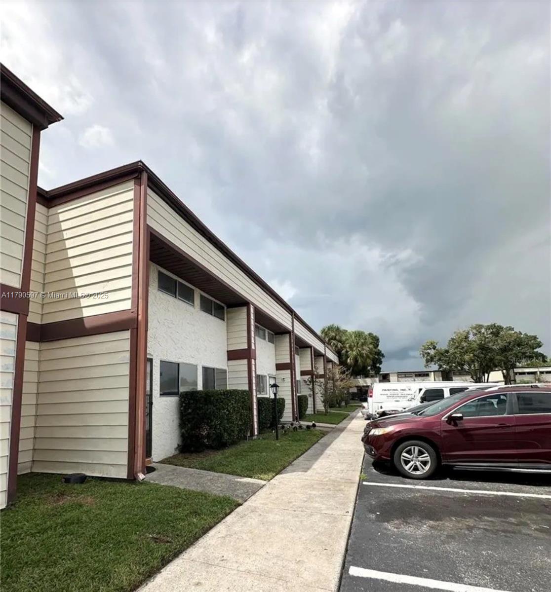 A two-story apartment building exterior with beige siding, stucco walls, and a parking lot — 4002 Dolomite # A, Orlando FL 32839, ORLANDO, FL