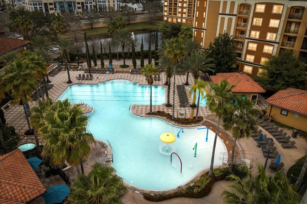 An aerial view of a resort-style swimming pool with a splash pad and lounge chairs — 12539 FLORIDAYS RESORT DRIVE UNIT 404D, ORLANDO, FL