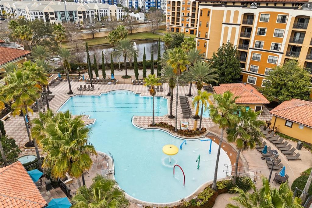 An aerial view of a large swimming pool with a splash pad and surrounding lounge chairs — 12539 FLORIDAYS RESORT DRIVE UNIT 404D, ORLANDO, FL