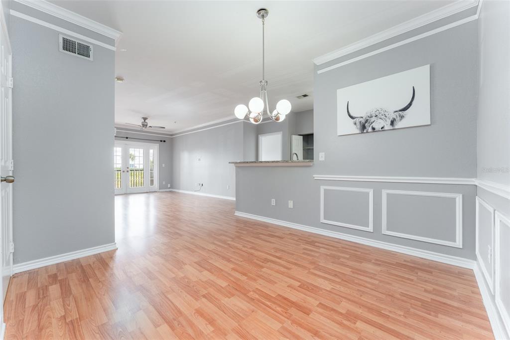 A dining area with light gray walls, wood-look flooring, and a modern globe light fixture — 4306 BAYSIDE VILLAGE DRIVE UNIT 202, TAMPA, FL