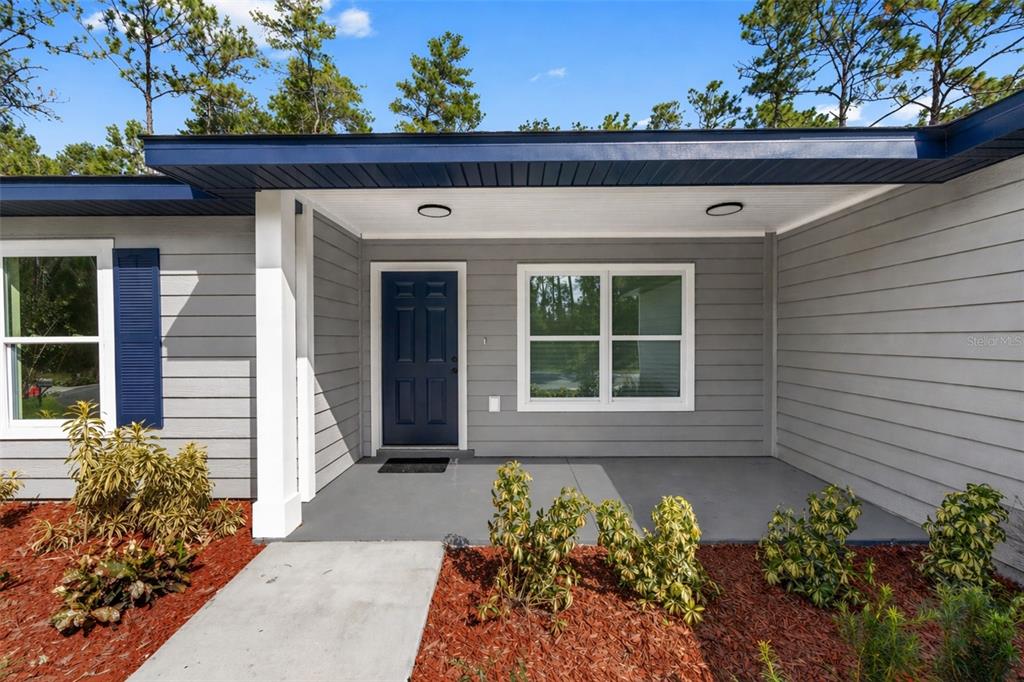 A single-story house with light blue siding, a two-car garage, and a concrete driveway — 8040 SW 133RD LANE, OCALA, FL