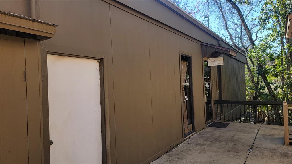 A brown exterior wall features a white door and a glass entrance door with signage — 2301 PARK AVENUE UNIT #300, ORANGE PARK, FL
