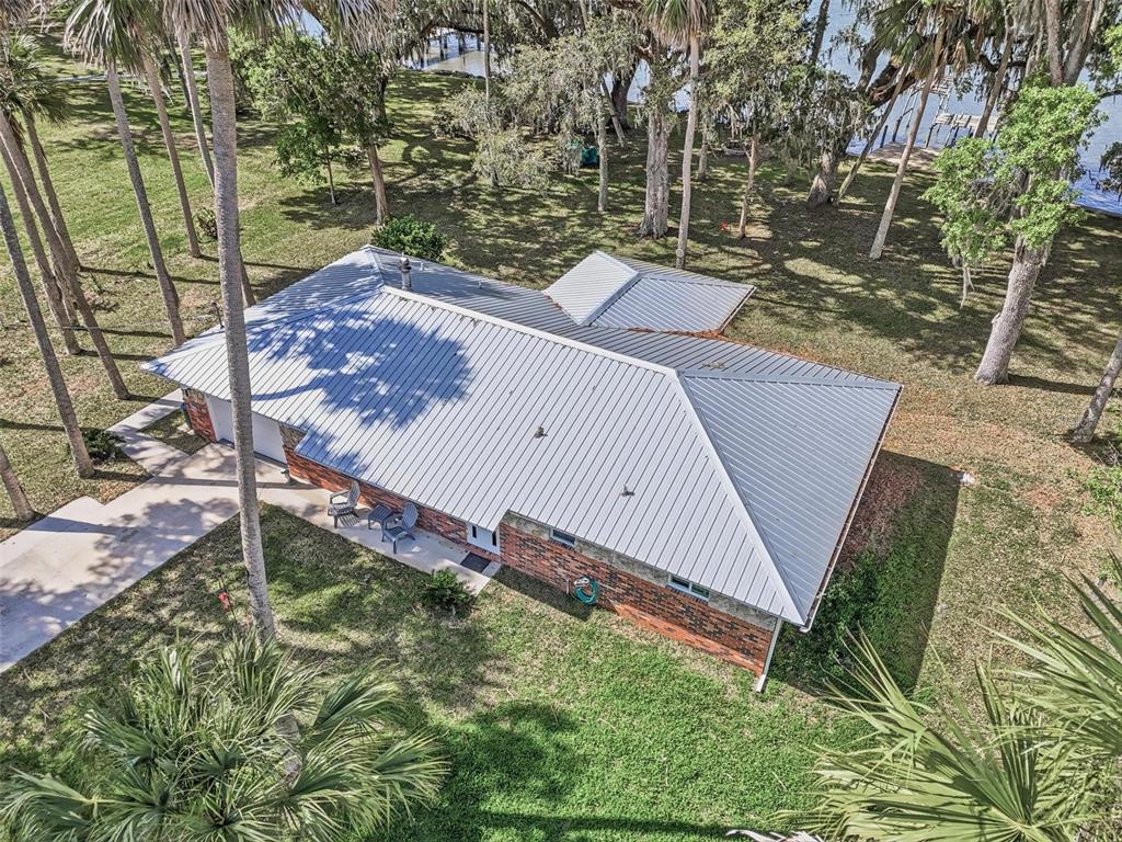An aerial view of a brick house with a metal roof surrounded by palm trees — 4368 N OCEAN SHORE BLVD, PALM COAST, FL