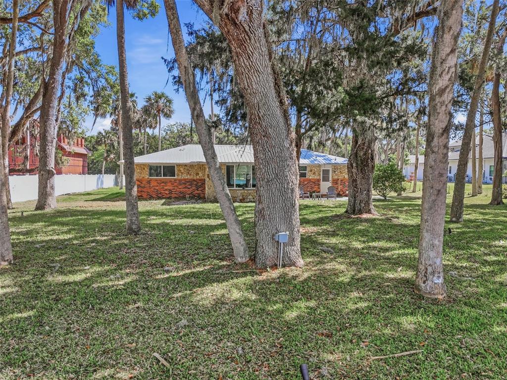 A single-story house with a brick and stone exterior sits in a tree-filled yard — 4368 N OCEAN SHORE BLVD, PALM COAST, FL