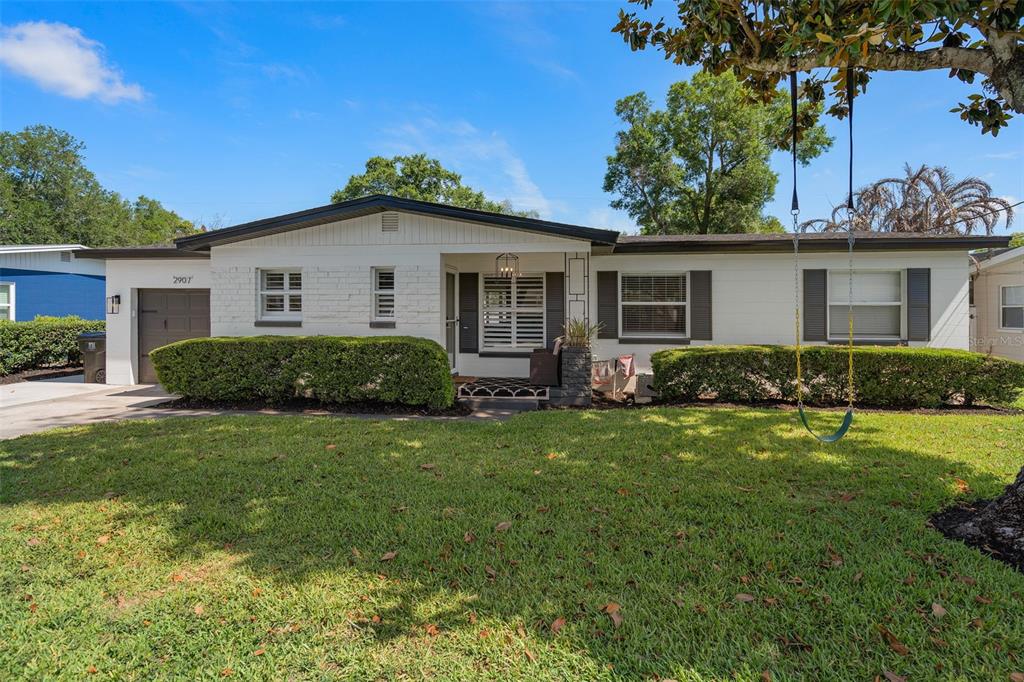 A single-story white brick house features a front porch, dark shutters, and a tree swing — 2907 VINE STREET, ORLANDO, FL