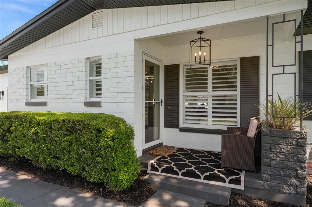 A white brick house exterior features a covered front porch with a patterned rug — 2907 VINE STREET, ORLANDO, FL