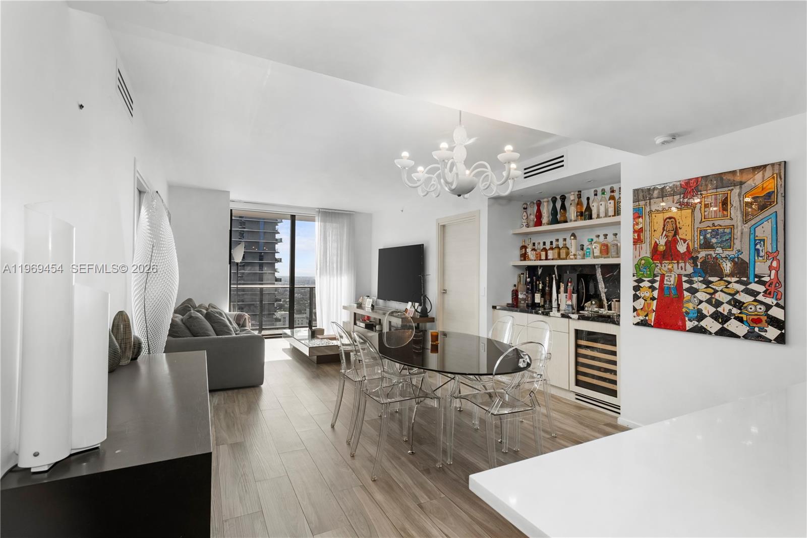 A modern living and dining room features a glass table, clear chairs, and a bar — 801 S Miami Ave # 3310, Miami FL 33130, MIAMI, FL