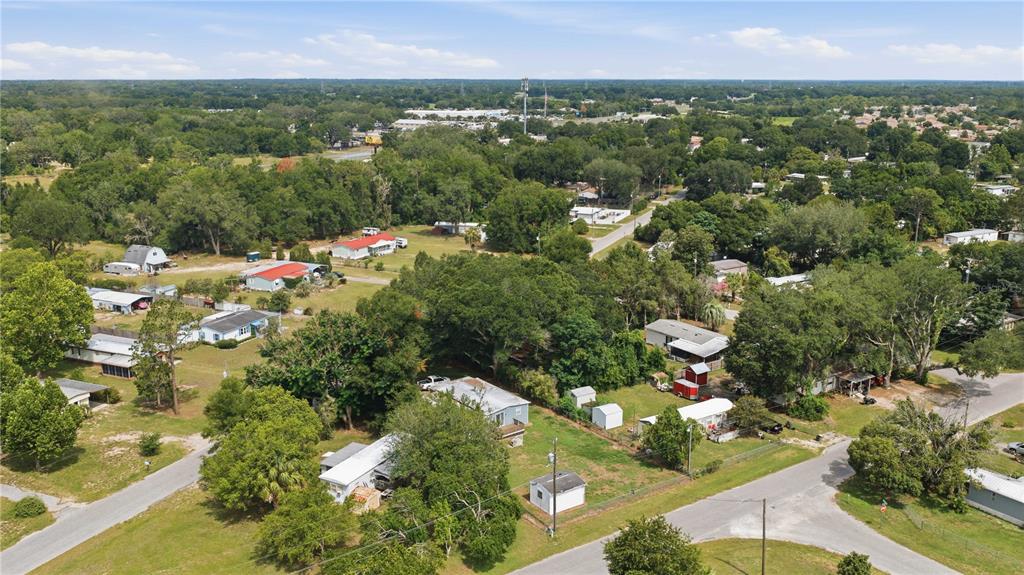 An aerial view shows several single-story homes and outbuildings situated among trees and grassy lots — 14615 SE 87TH TERRACE ROAD, SUMMERFIELD, FL
