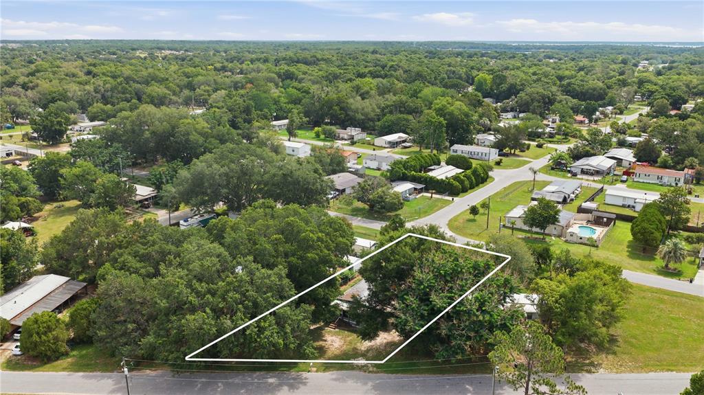An aerial view shows a residential lot outlined in white, featuring mature trees and vegetation — 14615 SE 87TH TERRACE ROAD, SUMMERFIELD, FL