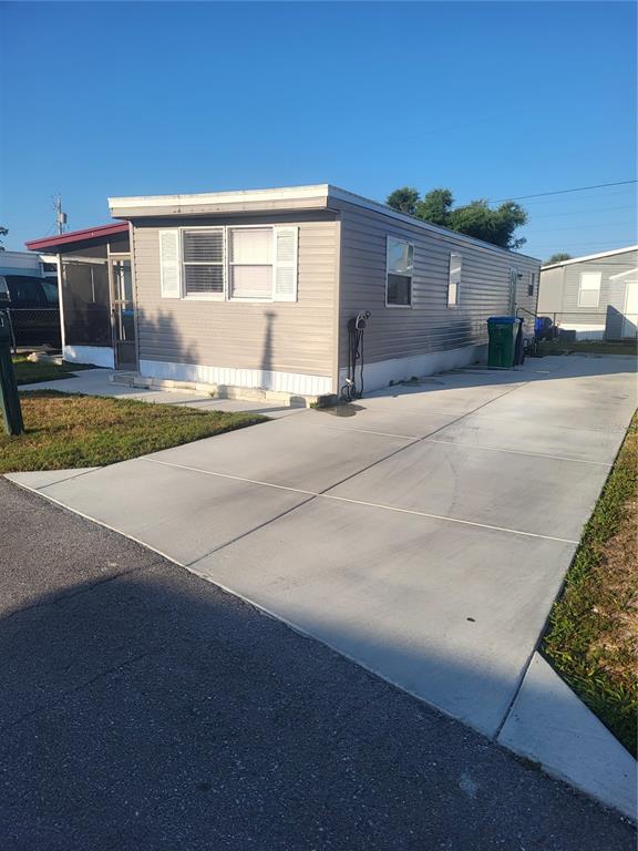 A single-story mobile home with light gray siding and a concrete driveway — 6580 SEMINOLE BOULEVARD UNIT 424, SEMINOLE, FL