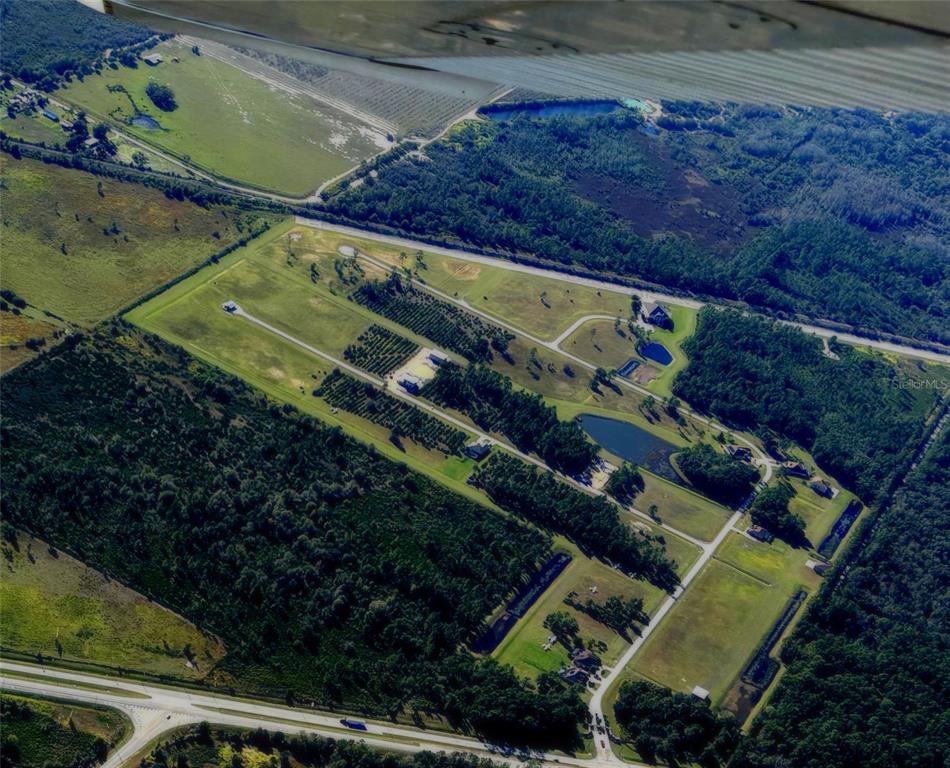 An aerial view shows a rural residential subdivision with several homes, ponds, and wooded areas — 4566 WRIGHTBROS ROAD, FROSTPROOF, FL