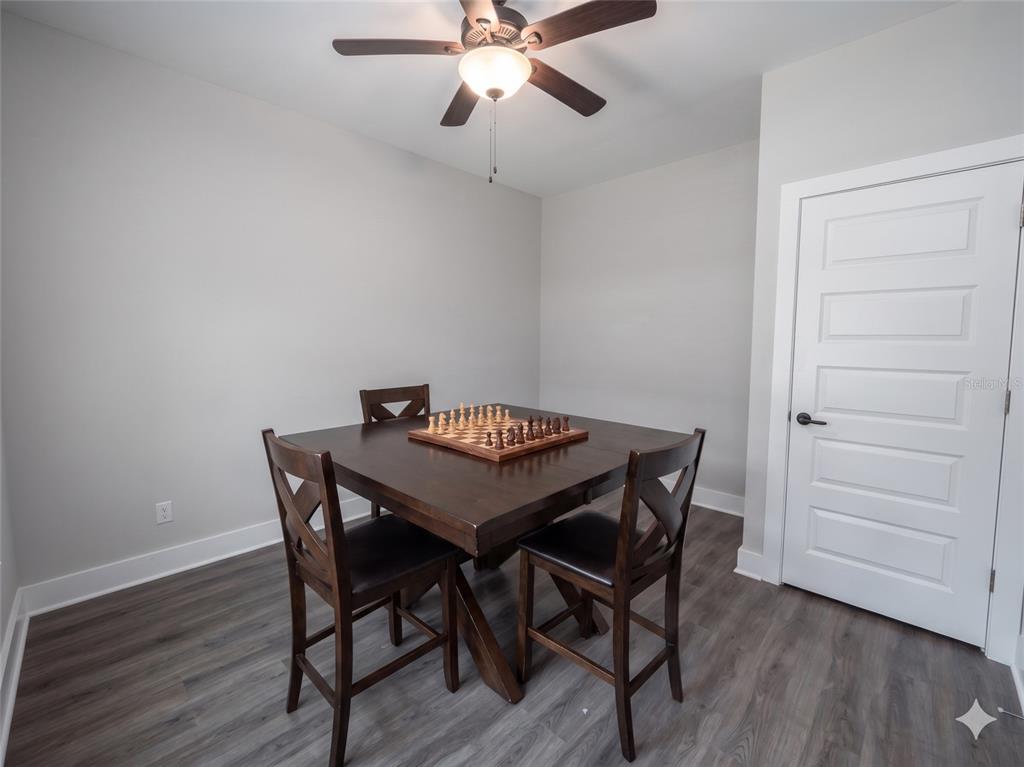 A dining room with a square wooden table, chess set, and dark wood chairs — 3044 N 7TH AVENUE, MILTON, FL