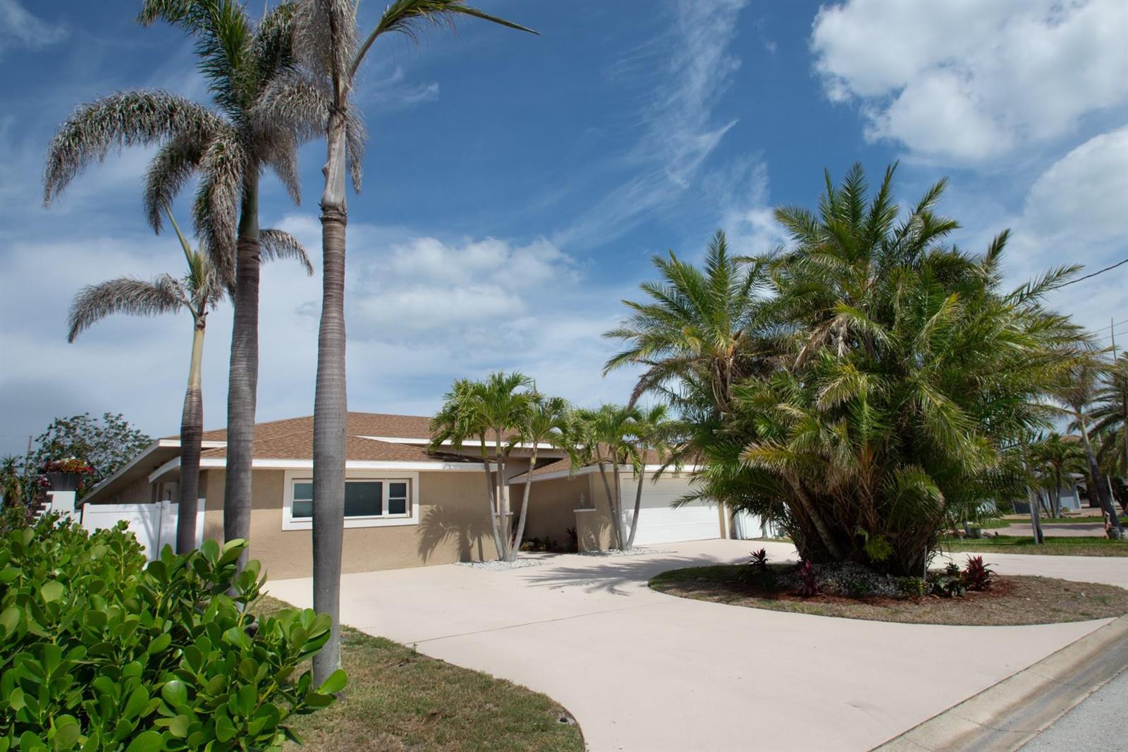 A single-story house with a beige exterior, a brown roof, and several palm trees — 2504 Hibiscus Drive, FL 33786, FL