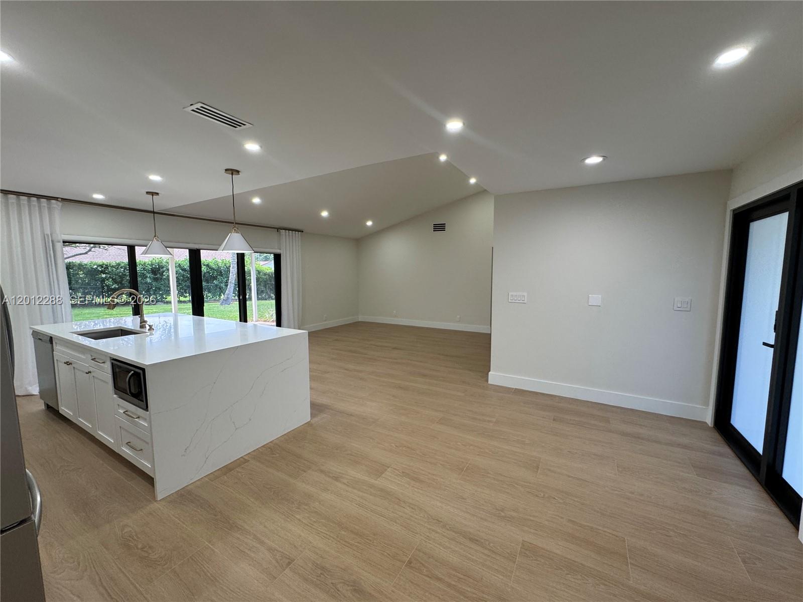 A kitchen island with white marble countertops sits in an open-concept room with light flooring — 9234 Southampton Pl, Boca Raton FL 33434, BOCA RATON, FL
