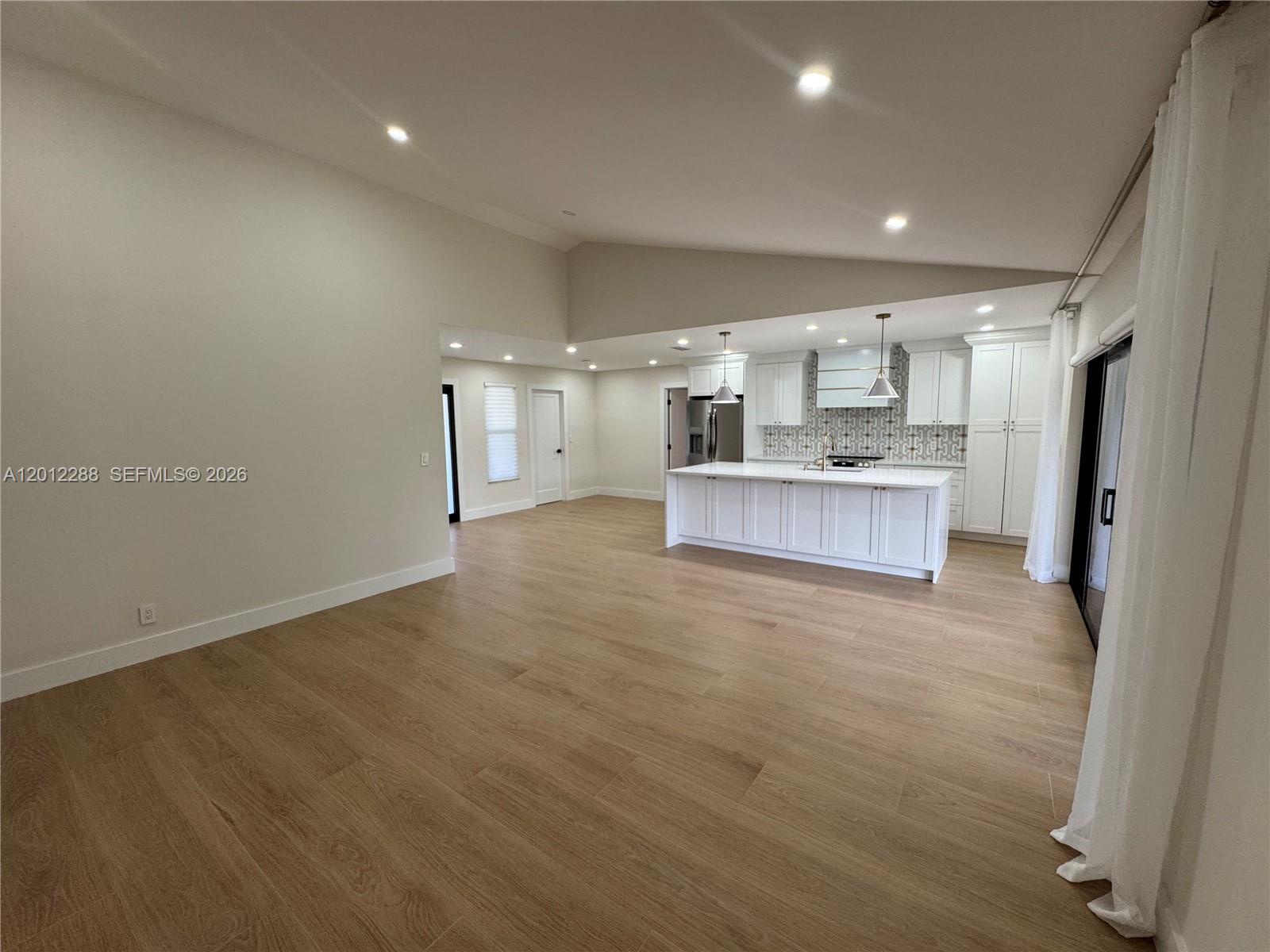 A spacious open-concept kitchen features white cabinetry, a large island, and light wood flooring — 9234 Southampton Pl, Boca Raton FL 33434, BOCA RATON, FL