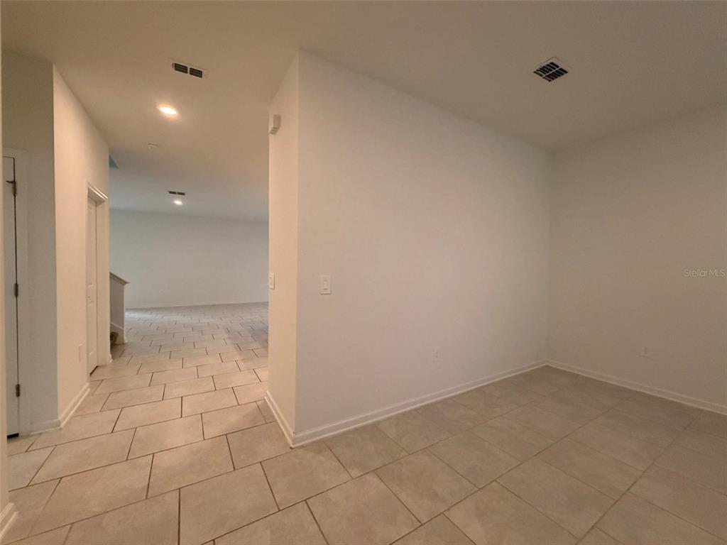 An interior view shows a tiled room with white walls and an adjacent hallway — 2165 SWEET HONEY LANE, APOPKA, FL