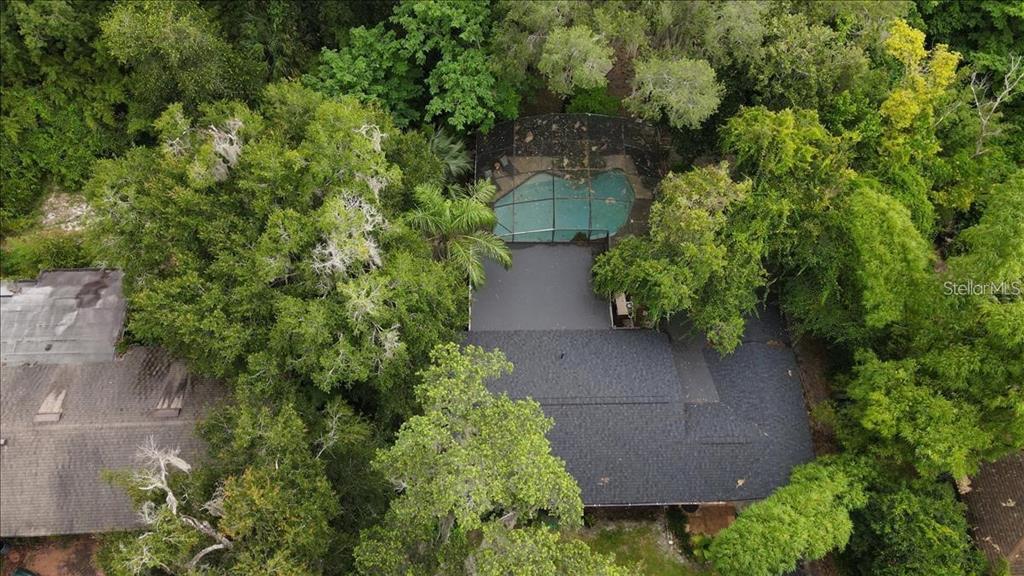 An aerial view shows a house with a dark shingled roof and a screened-in pool — 615 HERMITS TRAIL, ALTAMONTE SPRINGS, FL