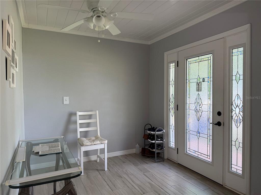 An entryway features light gray walls, wood-look tile flooring, a ceiling fan, and a glass door — 615 HERMITS TRAIL, ALTAMONTE SPRINGS, FL