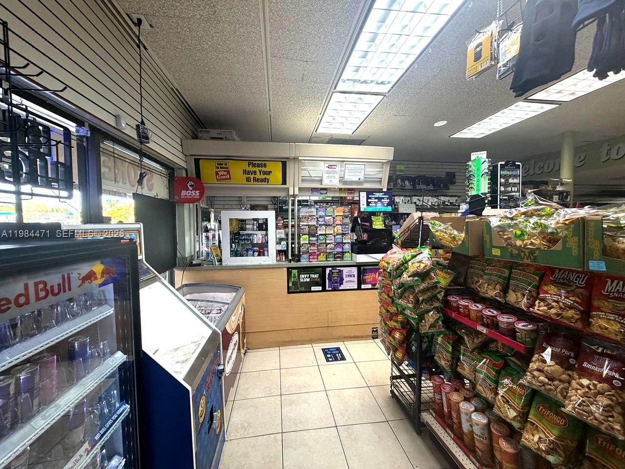A retail store interior features a service counter, snack displays, and a refrigerated beverage cooler — FORT LAUDERDALE, FL