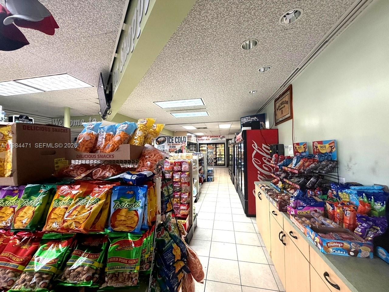 A convenience store interior features aisles of snack displays and refrigerated beverage cases — FORT LAUDERDALE, FL