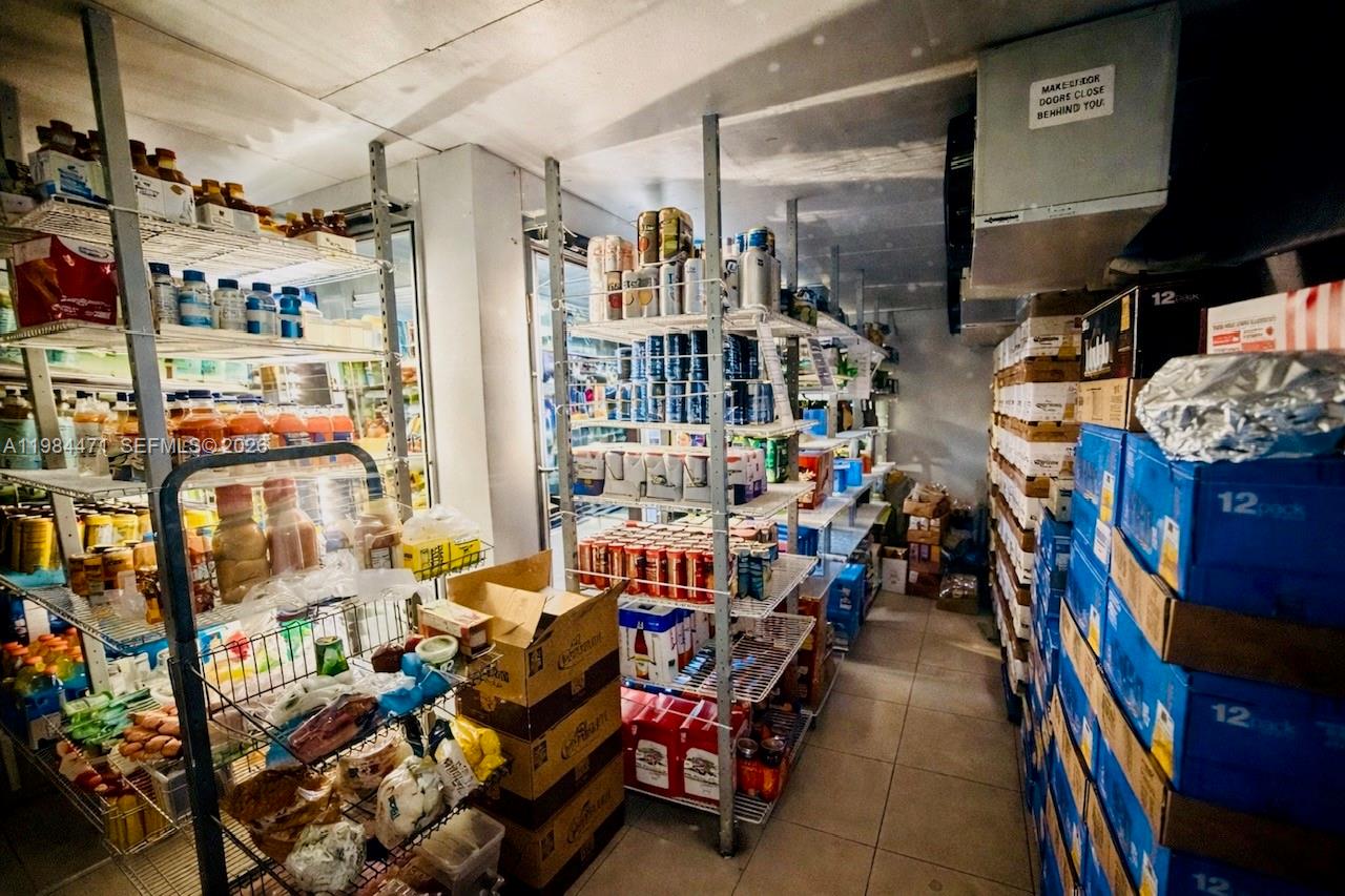 A commercial walk-in cooler features metal shelving units stocked with various food and beverage products — FORT LAUDERDALE, FL