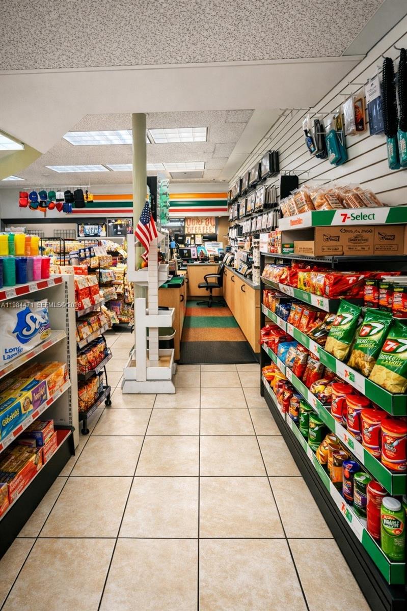 A 7-Eleven convenience store interior features tiled floors, stocked snack aisles, and a service counter — FORT LAUDERDALE, FL