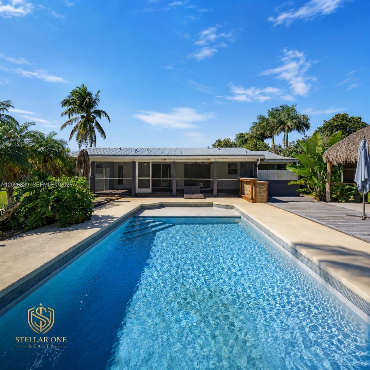 A wooden tiki hut with a thatched roof overlooks a backyard pool and red barn — 5300 SW 162nd Ave, Southwest Ranches FL 33331, SOUTHWEST RANCHES, FL