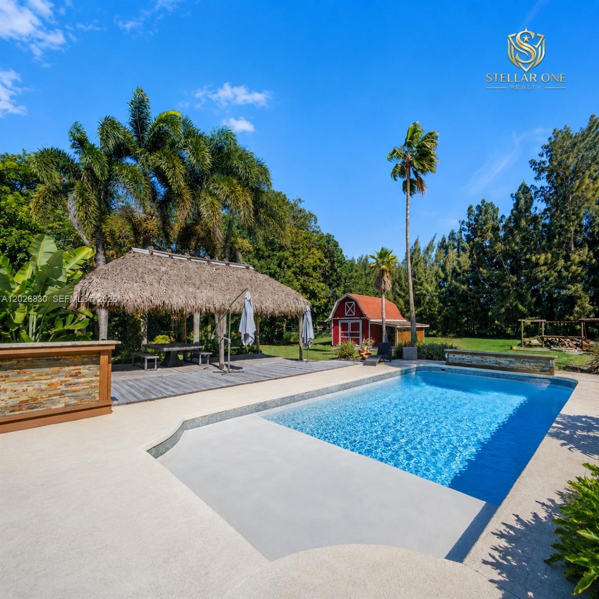 A swimming pool sits in front of a house with a screened-in patio and tiki hut — 5300 SW 162nd Ave, Southwest Ranches FL 33331, SOUTHWEST RANCHES, FL