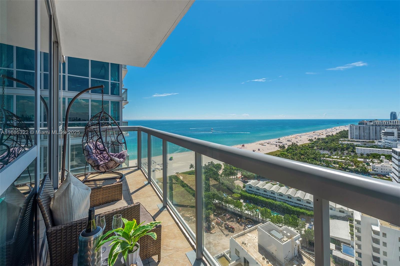 A high-rise balcony features a hanging chair, outdoor furniture, and a panoramic ocean view — 101 20th St # 2604, Miami Beach FL 33139, MIAMI BEACH, FL