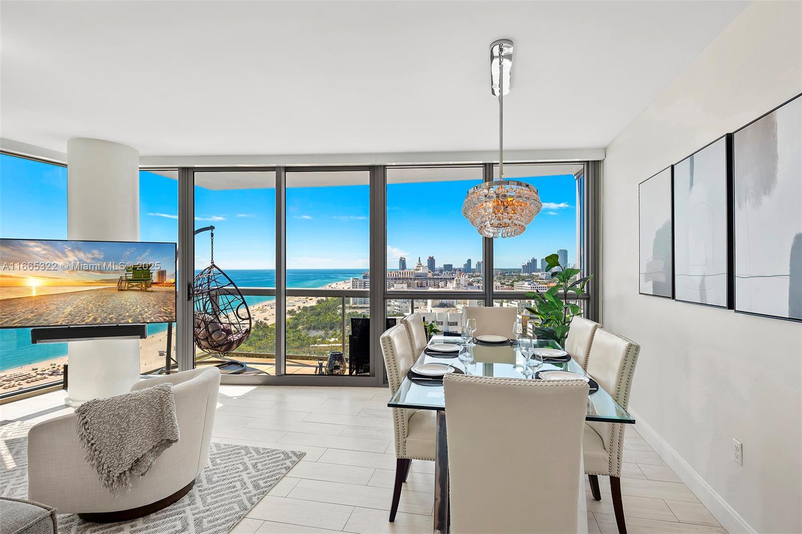 A dining room with a glass table, upholstered chairs, and floor-to-ceiling windows overlooking the ocean — 101 20th St # 2604, Miami Beach FL 33139, MIAMI BEACH, FL