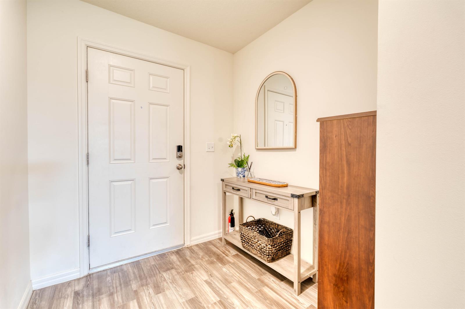 An entryway features a white door, a wooden console table, a mirror, and wood-look flooring — 773 SE 25TH Drive, Okeechobee FL 34974, OKEECHOBEE, FL