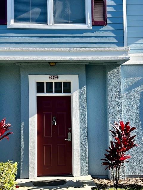 A blue exterior wall features a dark red front door with a silver handle — 4012 SANTA MARIA DRIVE UNIT 102, KISSIMMEE, FL