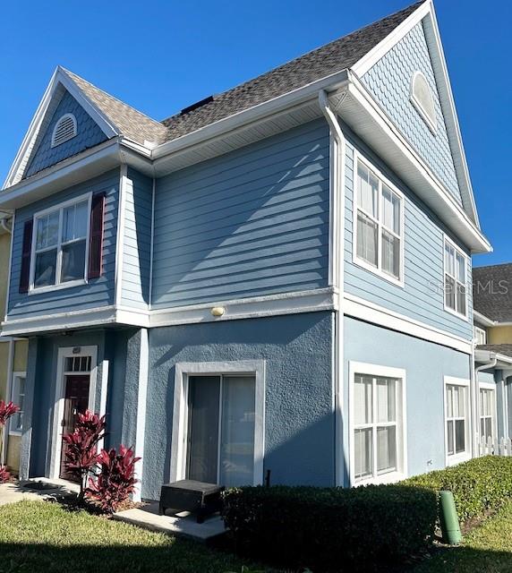 A two-story blue house with horizontal siding, a gabled roof, and a sliding glass door — 4012 SANTA MARIA DRIVE UNIT 102, KISSIMMEE, FL