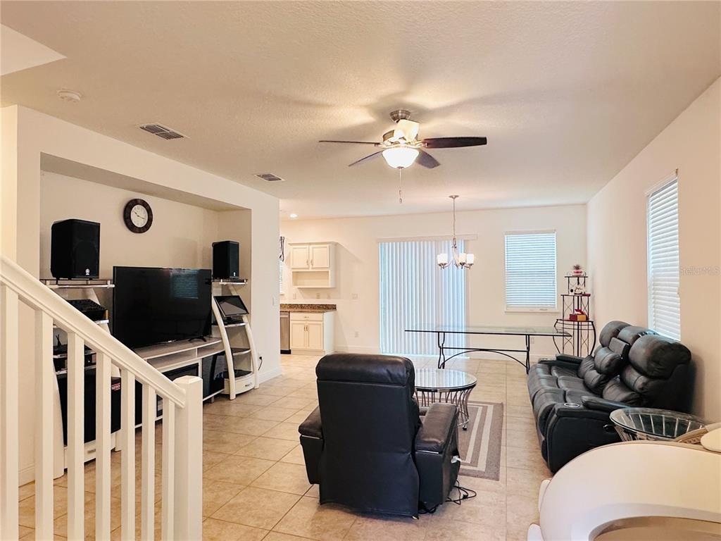 A living room with tile floors, a ceiling fan, and an open kitchen in the background — 10132 GRAND OAK CIRCLE, MADEIRA BEACH, FL