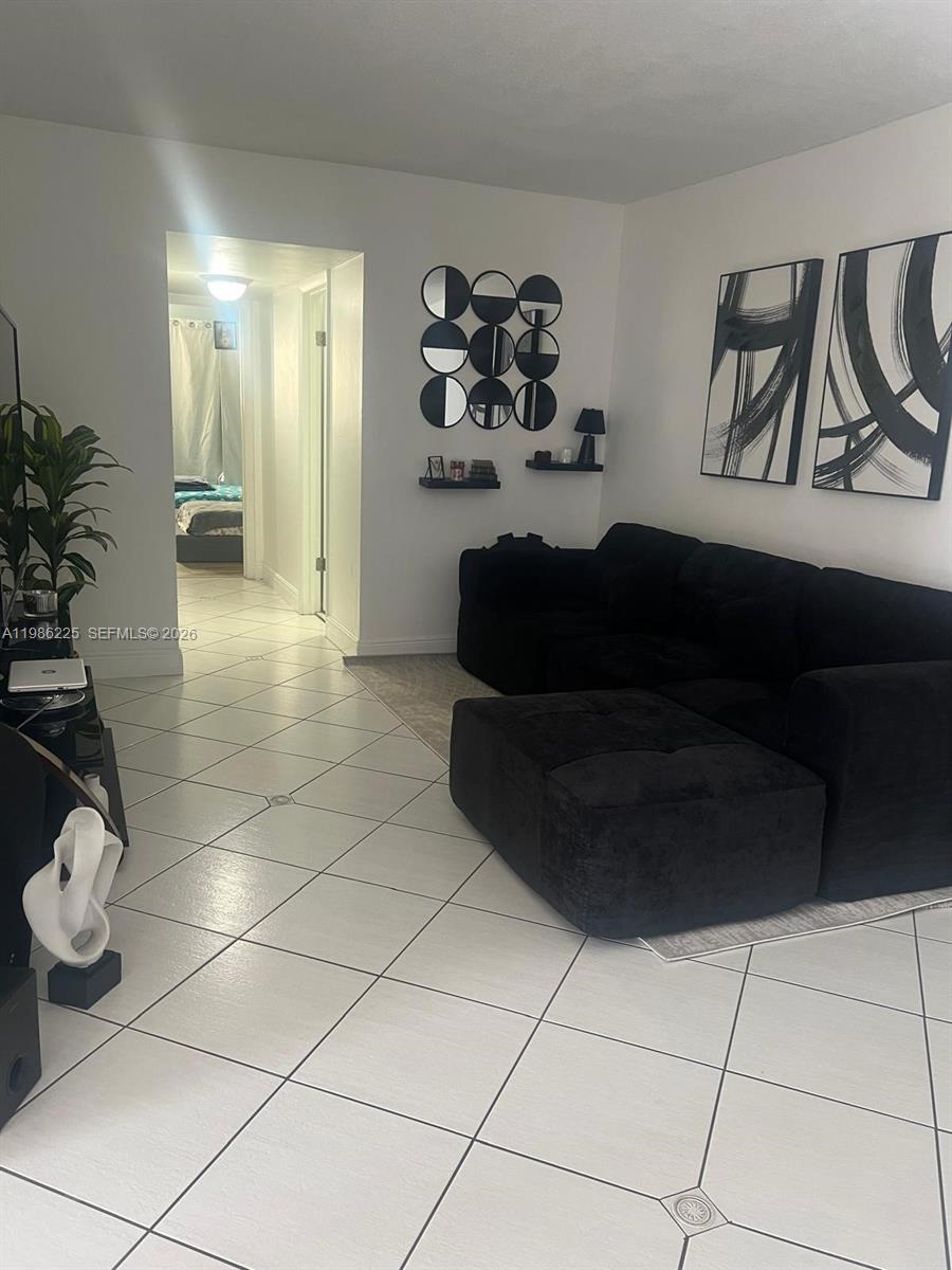 A dining area features a glass-topped table with dark chairs and vertical window blinds — 6620 W 2nd Ct # 407, Hialeah FL 33012, HIALEAH, FL