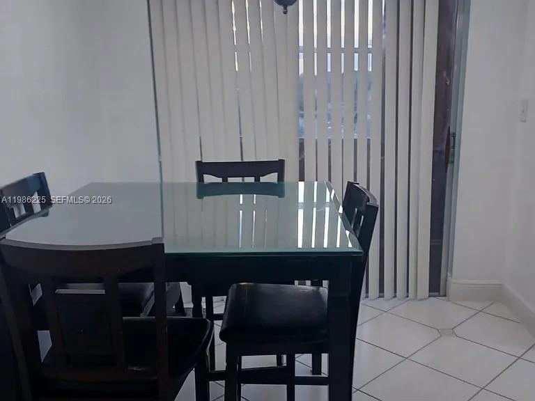 A small kitchen features white cabinets, a white stove, and tiled countertops and floors — 6620 W 2nd Ct # 407, Hialeah FL 33012, HIALEAH, FL